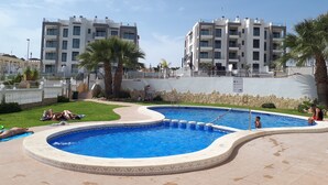 A swimming pool area with a curved design, surrounded by a stone wall and a white fence. - Top renovated holiday home with AC, Wi-Fi, satellite, infrared heating (Villamartin)