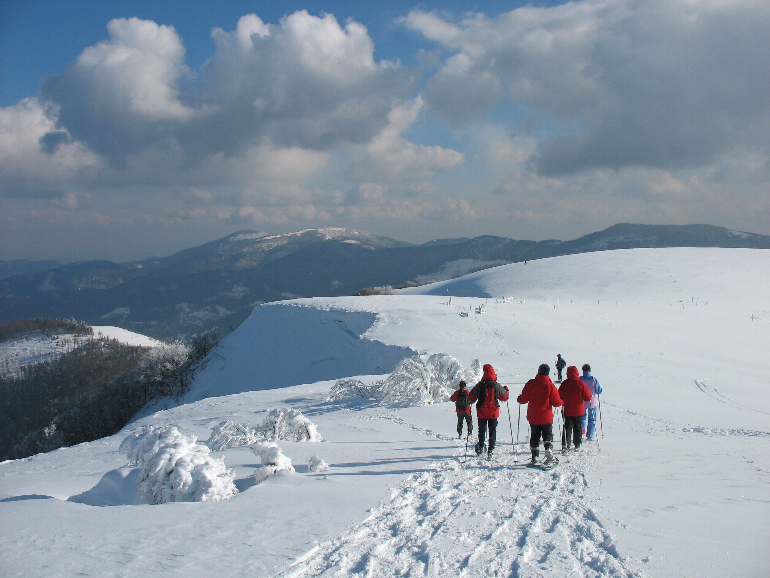 A snowy mountain landscape with a group of people hiking.