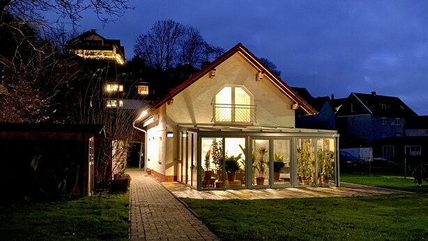 A house with a covered patio area, a brick pathway leading to the entrance, and a lawn. - Vacation home with pet-friendly large fenced garden in Bad Tabarz. (Tabarz/Thüringer Wald)