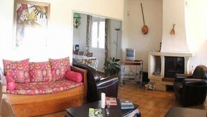 A living room with a sofa, a fireplace, and a television. - Superb villa with sea view, all mod cons,pool and private garden, Wifi (Portiragnes)