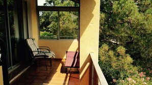 A balcony with tiled flooring, two chairs, and a view of greenery and flowers. - Superb villa with sea view, all mod cons,pool and private garden, Wifi (Portiragnes)