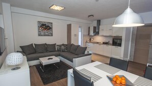 A modern apartment with a living area, kitchen, and dining space.
