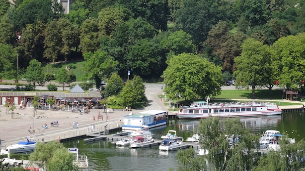 A riverside area with a dock, boats, and a water tower. - 4 * FH with garden, playground, sauna, fitness, 2 bedrooms, kitchen with dishwasher (Ludorf)