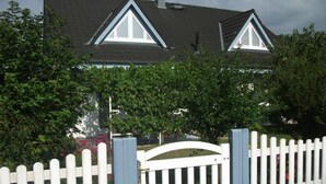 A house with a white picket fence, a dark roof, and a triangular window design. - 3-star vacation apartment on the Rheinsteig with a magnificent view over the Rhine Valley (Rüdesheim am Rhein)