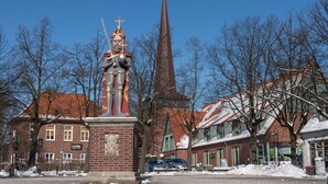 A statue of a knight in armor with a helmet and sword, standing on a pedestal in a town square. - Beautiful apartment in a central location in Wedel (Hamburg) (Wedel)