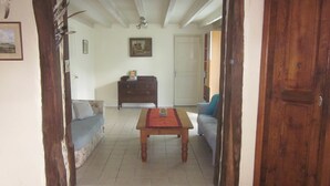 Un salon avec un canapé, une table en bois et une commode.