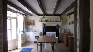Une cuisine avec une table et des chaises en bois, une cuisinière et un évier.