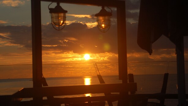 A sunset view through a framed window with two lanterns, overlooking the sea. - Characteristic apartment, renovated, 500m from the sea, beach and town center (Vlissingen)