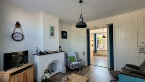 A living room with a fireplace, a television, and a coffee table. - Characteristic apartment, renovated, 500m from the sea, beach and town center (Vlissingen)