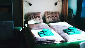 A bed with two pillows, a wooden headboard, and a bedside table. - Characteristic apartment, renovated, 500m from the sea, beach and town center (Vlissingen)
