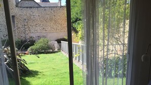 Una camera da letto con un'ampia porta-finestra che si apre su un giardino.