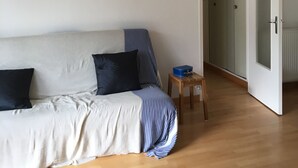 Un soggiorno moderno con un divano, un tavolino e una porta che dà su un'altra stanza.