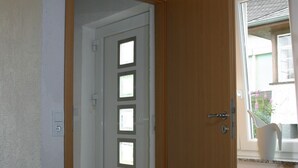 A hallway with a wooden door leading to a room with a window. - Detached holiday home, Apartment 2 / for 2-4 persons, W-LAn free (Mehren)