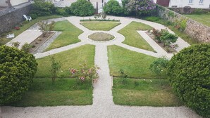 Ein angelegter Garten mit einer zentralen, runden Gestaltung und umlaufenden Rasenflächen.