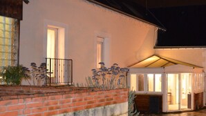 A house with a brick facade, a small porch with a railing, and a covered entryway. - Gîte de la Merluchette  (Nazelles-Négron)