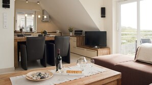 Ett modernt vardagsrum med ett soffbord i trä, en soffa och en tv som står på ett tv-bord.