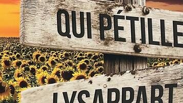A wooden sign with the text "UN SEJOUR QUI PETIT LYSAPPART" against a sunset sky and sunflower field.