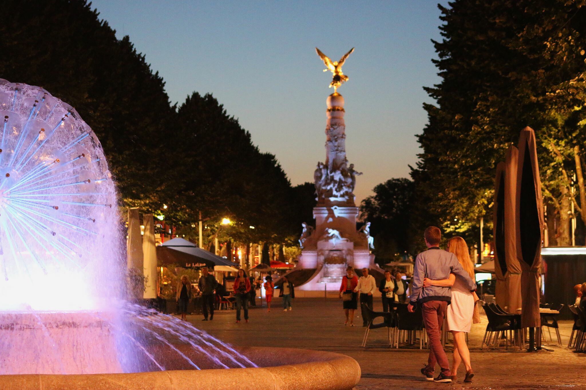 Una plaza pública con una fuente, una estatua y zonas de estar al aire libre.