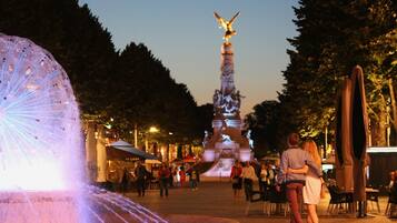 Una plaza pública con una fuente, una estatua y zonas de estar al aire libre.