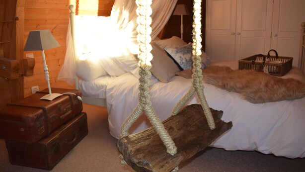 A cozy bedroom with a bed, a hanging chair, a lamp, and wooden furniture. - Charming rooms with view  (La Roque-Gageac)
