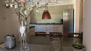 Una cucina moderna con mobili in legno, un frigorifero in acciaio inossidabile e una lampada a sospensione.