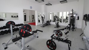 A gym with various exercise equipment, including weight machines and dumbbells.