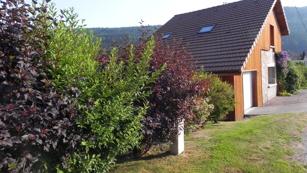 A house with a sloped roof, a garage, and a well-maintained lawn.