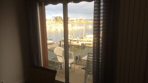 A room with a view of a marina through a sliding glass door. -  ENEZ BREHAT, Residence LE PORT, marina, Your balcony on the Port, (Perros-Guirec)