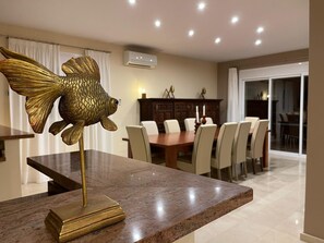 A dining area with a marble table, chairs, and a decorative fish sculpture. - Beautiful 5 bedroom 5 bathroom villa with panoramic views and private pool (Mijas Costa)