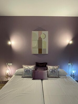 A bedroom with a bed, two bedside lamps, and a wall-mounted abstract painting. - Beautiful 5 bedroom 5 bathroom villa with panoramic views and private pool (Mijas Costa)