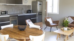 Een moderne keuken met een eethoek, een bank en een potplant.