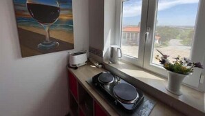 Eine Küche mit Fenster, einem Weinbild, einem Toaster und einem Wasserkocher.