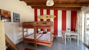 Ein Zimmer mit einem Etagenbett, einem Tisch und einer Pendelleuchte.