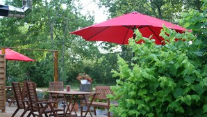 An outdoor patio with wooden furniture and red umbrellas. - Apartment between the Atlantic Ocean, vineyards and "Mirabelle" pine forests (Brach)