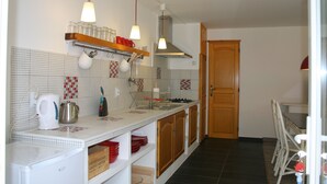A kitchen with a white countertop, wooden cabinets, a stainless steel range hood, and a tiled backsplash. - Apartment between the Atlantic Ocean, vineyards and "Mirabelle" pine forests (Brach)