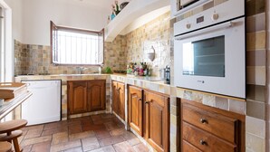 A kitchen with a dishwasher, wooden cabinets, a tiled backsplash, and a large oven. - wonderful allround view  on S. Tropez bay (Roquebrune-Sur-Argens)
