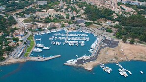 An aerial view of a marina with numerous boats docked, surrounded by residential buildings and greenery. - 100m from downtown and the stores, 300m from the beach and the marina (Porto-Vecchio)