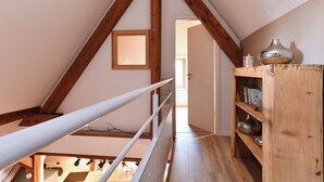 A wooden staircase with a metal railing leading to an upper floor. A wooden bookshelf with decorative items is visible on the right. - Beraweka ***, Apartment for 4 to 6 people in the historic center of Colmar - 2 bedrooms, bathroom,... (Colmar)
