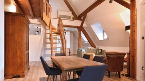 A dining area with a wooden table and chairs, a staircase, and a loft space with a skylight. - Beraweka ***, Apartment for 4 to 6 people in the historic center of Colmar - 2 bedrooms, bathroom,... (Colmar)