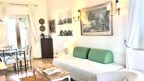 A cozy living room with a sofa, a small table, a coffee table, and a dining area with chairs. -  Pool, whirlpool, garden, internet WiFi close to Rome. Relax and rest. (Monte Migliore-la Selvotta)