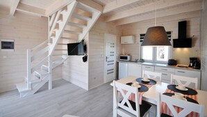 Een moderne keuken met witte kasten, een ingebouwde magnetron en een koffieapparaat.