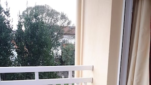 A wooden table set for two with plates, glasses, and a bottle of wine on a balcony. - T2 apartment + 2 terraces + 1 private secure PARKING + WIFI + TV. (Biarritz)
