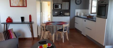 Un espacio habitable compacto con comedor, kitchenette y sofá.