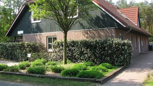 Een gebouw met twee verdiepingen, een bakstenen gevel en een dak van rode tegels.