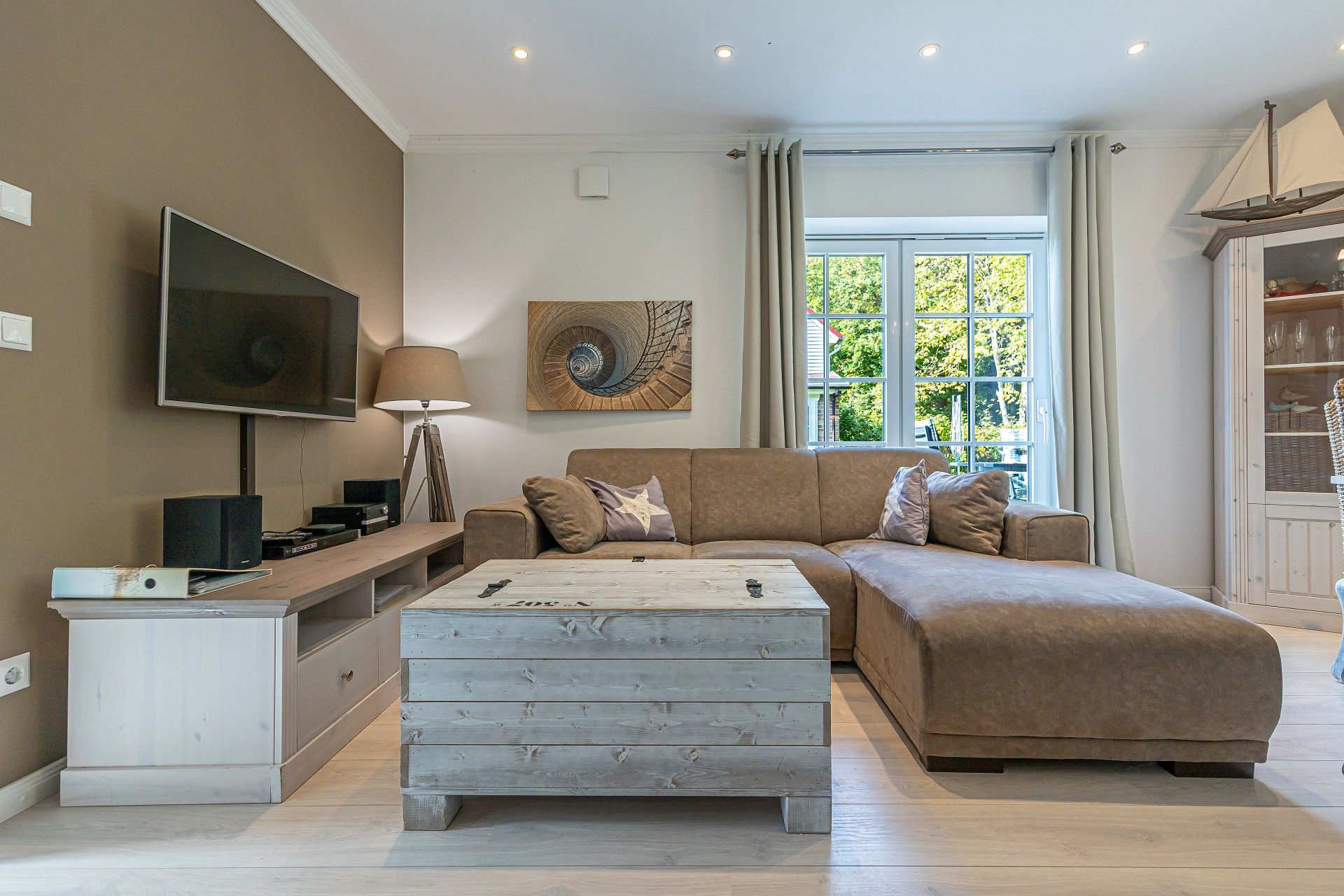 A modern living room with a sofa, coffee table, TV, and a decorative wall piece.
