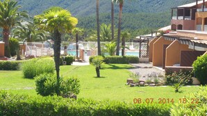 Un complexe hôtelier doté d’une piscine, de palmiers et avec des montagnes en toile de fond.