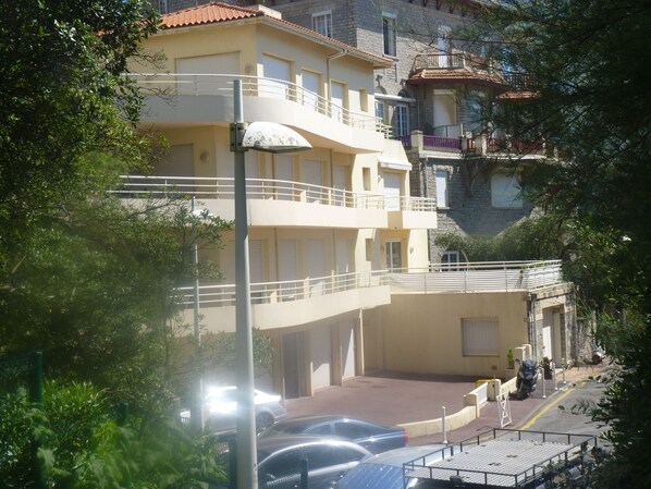 Ein mehrstöckiges Gebäude mit Balkonen, einem Parkplatz und Blick auf die Straße.