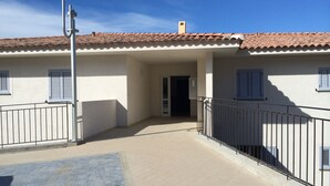 A building with a tiled roof, a balcony with metal railings, and a tiled floor. - BEAUTIFUL APARTMENT IN RESIDENCE STANDING UP BEAUTIFUL SEA AND MOUNTAIN (L'île-Rousse)