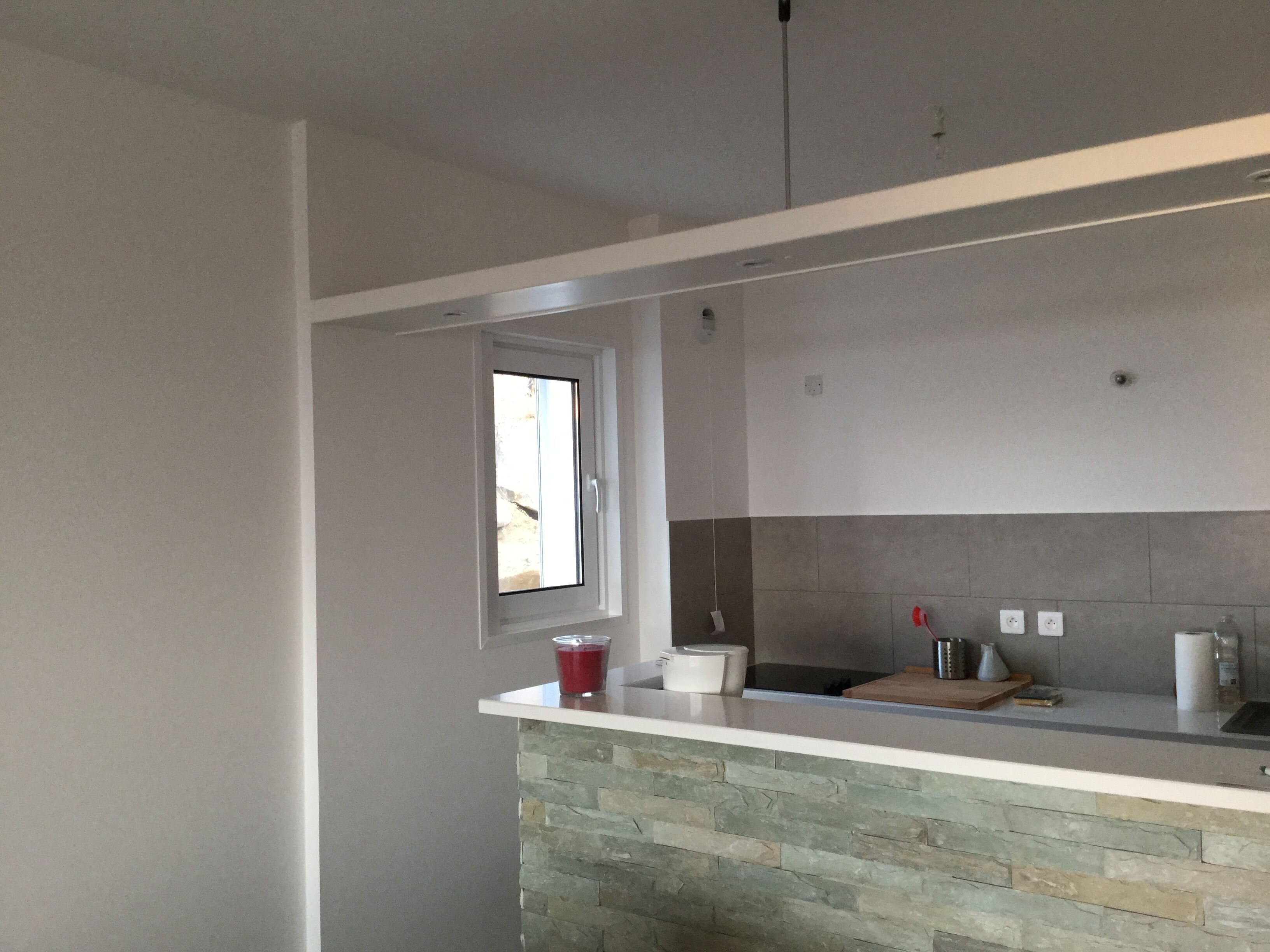 A kitchen with a stone countertop, a window, and a built-in oven.