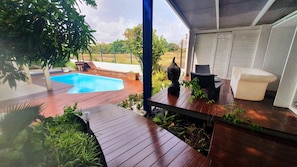 A wooden deck with a pool, outdoor furniture, and a Buddha statue. - Unique in Guadeloupe: Villa 400 m from the beach with mango tree house (Le Gosier)